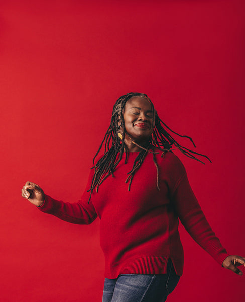 Joyful black woman dancing and whipping her dreadlocks