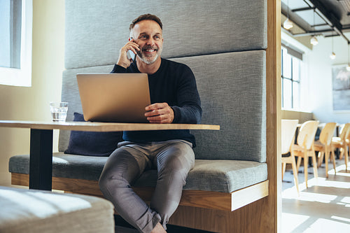Experienced businessman smiling during a phone call