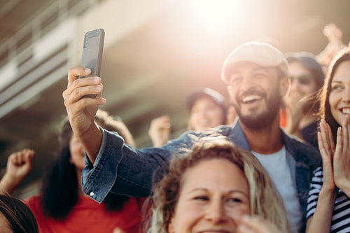 Excited couple taking selfie at stadium