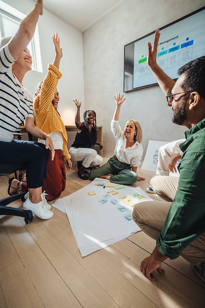 Architect team celebrating success in a collaborative workspace with diverse colleagues