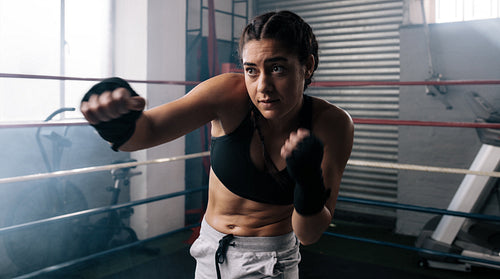 Female boxer training inside a boxing ring