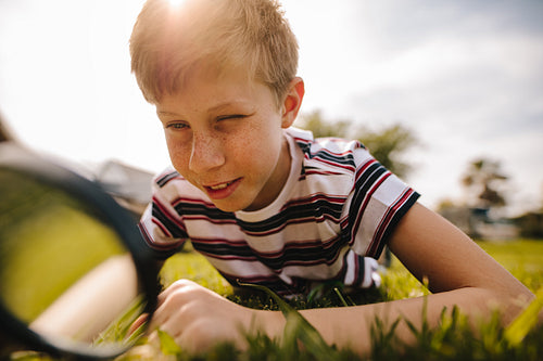 Boy exploring nature with magnifying glass