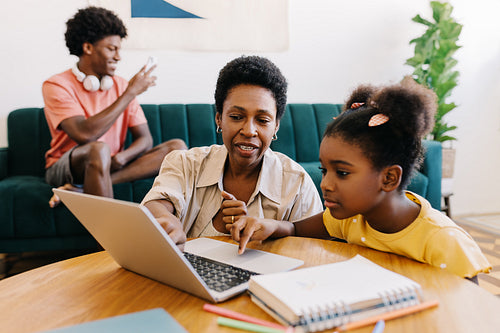 Mom homeshooling her daughter with a laptop