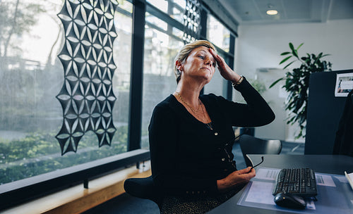 Stressed out businesswoman at her office desk