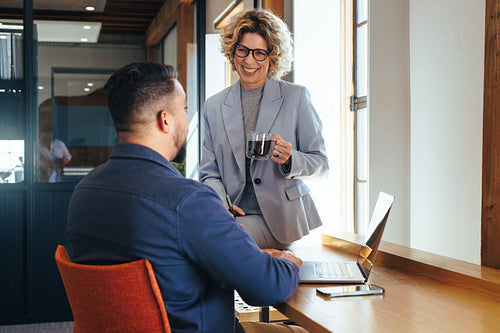 Mature business woman talking to her colleague in a coworking office