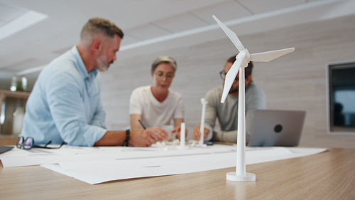 Business woman leading a team of engineers on a wind turbine design project
