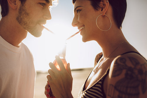Couple enjoying drinking cold drink outdoors