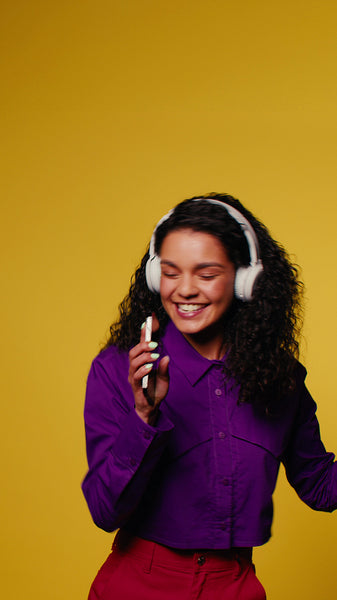 Woman dances and sings with headphones in studio