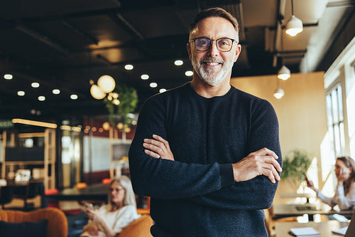 Mature businessman standing in a co-working space