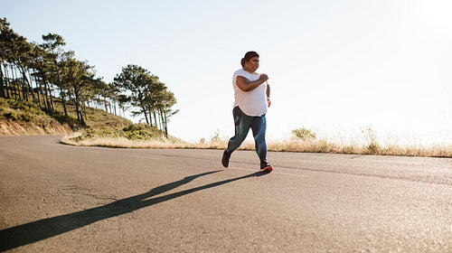 Overweight female jogging in morning