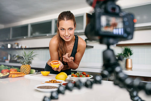 Young female blogger recording content for videoblog in Kitchen.