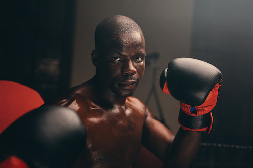 Strong young boxer training with boxing gloves
