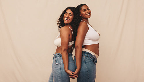 Friends holding hands and smiling in a studio