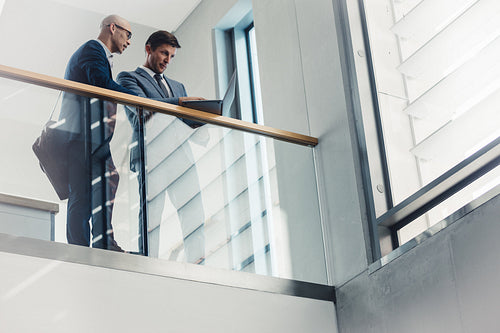 Two businessmen working at laptop