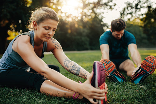 Beautiful young woman stretching with man