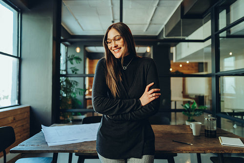 Happy young businesswoman smiling cheerfully in a modern office