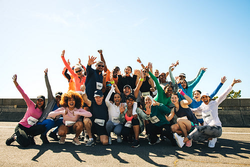 Marathon participants posing for a joyful group photo outdoors