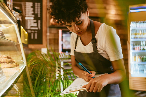 Barista checking stock in dessert showcase