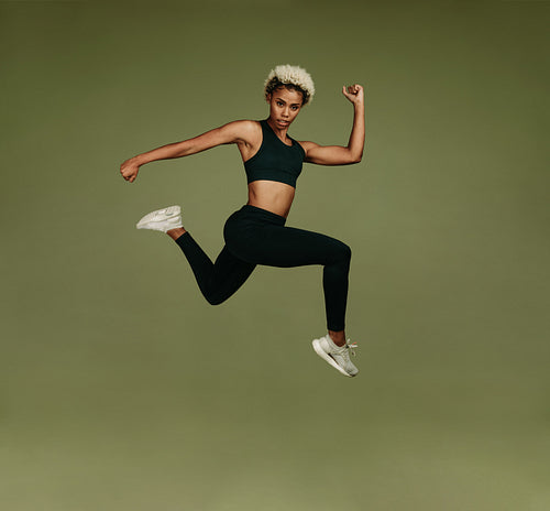 Athletic woman jumping in air