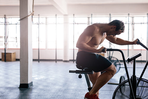 Fitness man spinning stationary bicycle