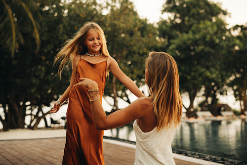 Mother and daughter bonding in a tropical setting by the pool