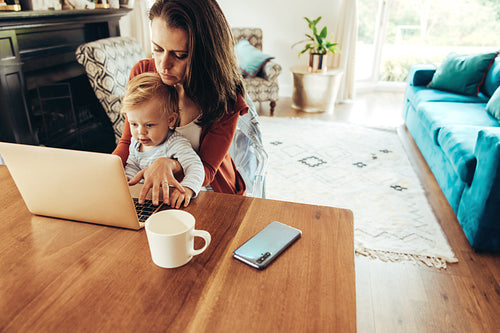 Working mother with her baby at home