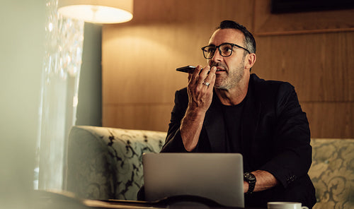 Businessman on trip working from hotel lobby