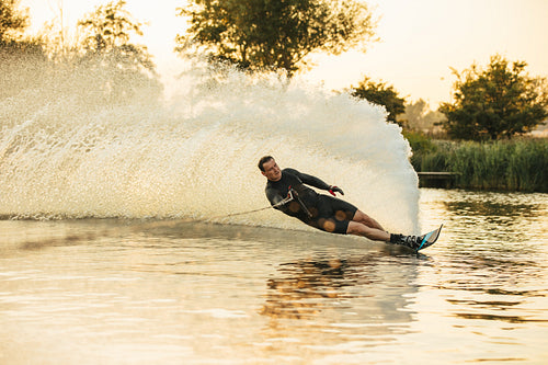 Athlete doing stunts on wakeboard in lake