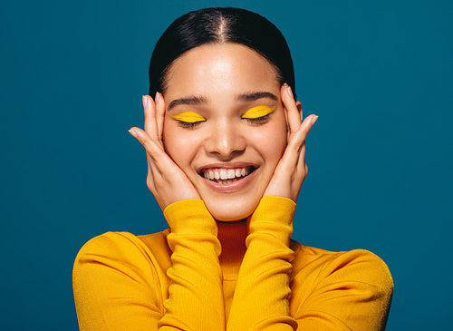 Empowered and confident in her own skin, young woman embraces face with makeup