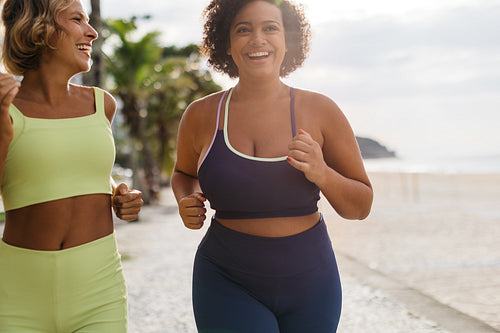 Fitness women running and jogging on the beach promenade together