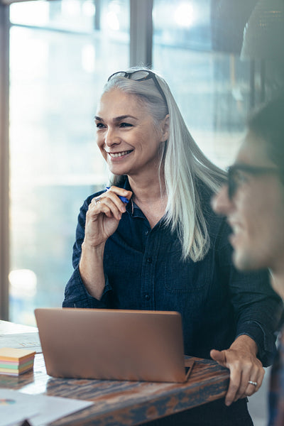 Happy business woman in meeting with coworkers