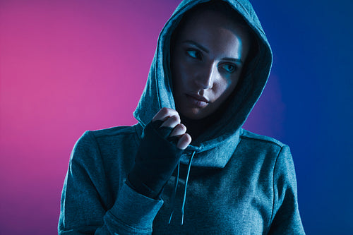 Sportswoman in hooded shirt looking away