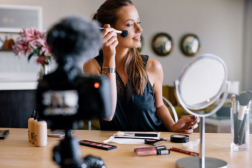 Young female vlogger recording a make-up broadcast.