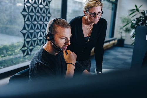 Businessman with headset working at his desk with manager
