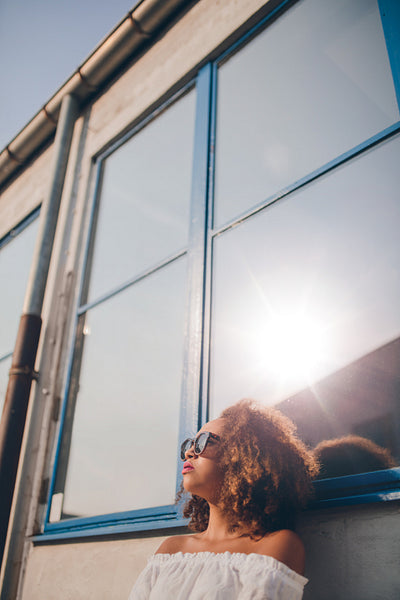 Beautiful african woman sitting outdoors and looking away
