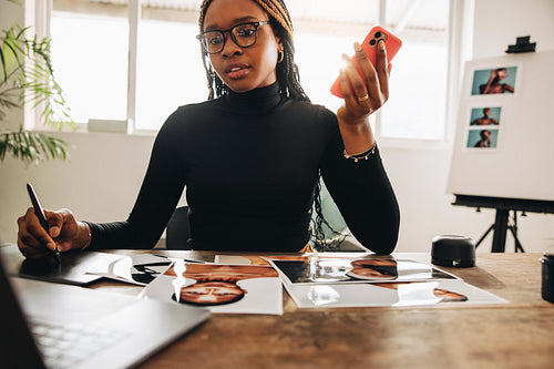 Graphic designer taking a phone call in her office