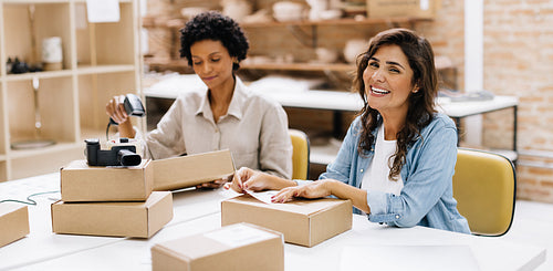 Happy online store owner smiling at the camera in a warehouse