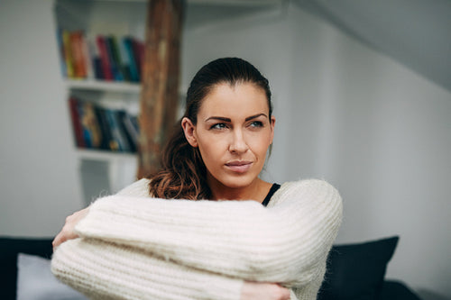 Pretty young lady at home looking away