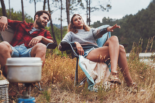 Relaxed young couple camping by the lake