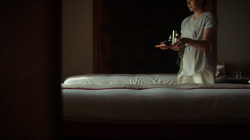 Spa therapist preparing for a relaxing massage room in a tranquil wellness center setting