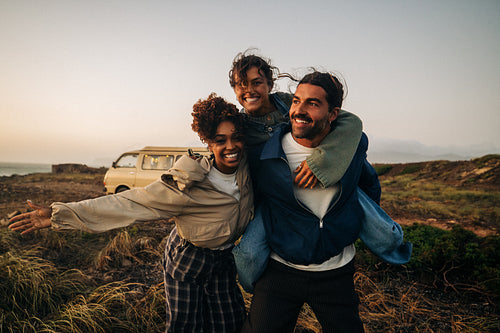 Friends posing together outdoors at sunset