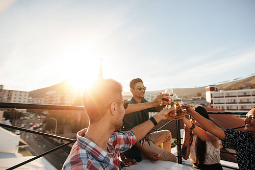 Friends toasting drinks at rooftop party