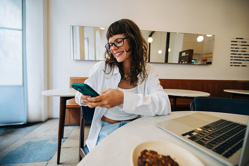 Young business woman using smartphone in cafe