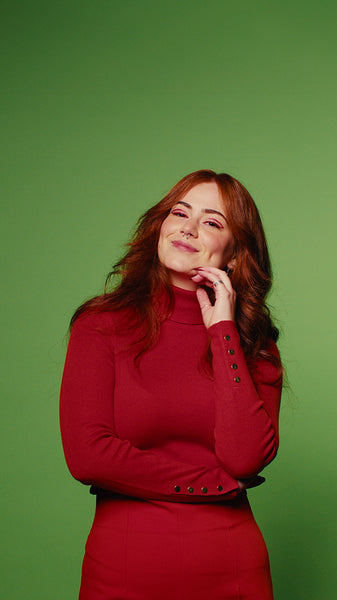 Happy young woman in red poses on green screen background