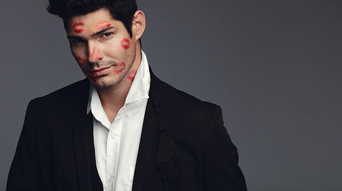 Stylish man covered with kisses