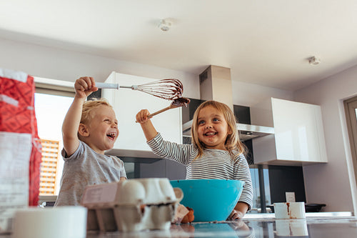 Siblings enjoying baking in kitchen