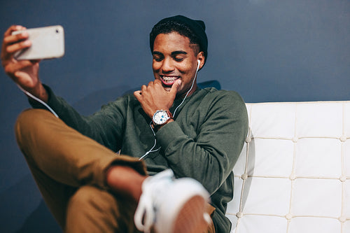 Happy young businessman taking a selfie in an office lobby
