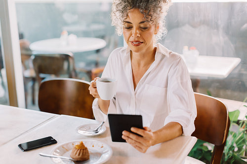 Modern businesswoman using a digital tablet in a coffee shop