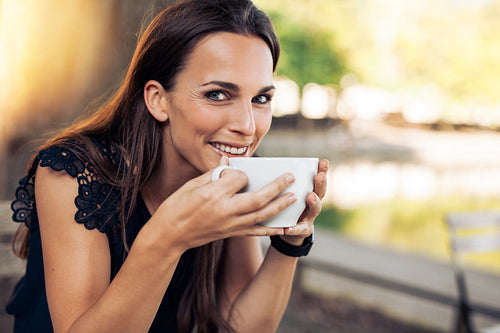 Cheerful woman enjoying a cup coffee