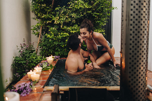 Cheerful young couple going in for a kiss in a plunge pool